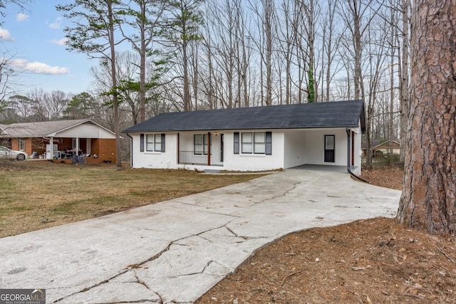 ranch-style home featuring a front lawn, a carport, and a porch