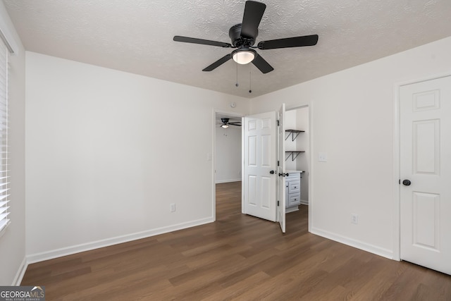 unfurnished bedroom with ceiling fan, dark hardwood / wood-style floors, and a textured ceiling