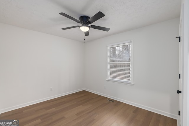 unfurnished room featuring ceiling fan, hardwood / wood-style floors, and a textured ceiling