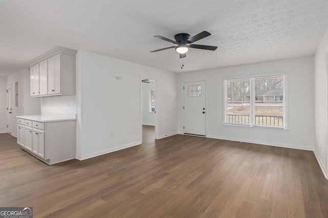 unfurnished living room featuring hardwood / wood-style flooring, a textured ceiling, and ceiling fan