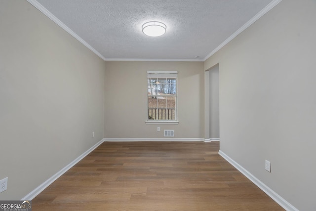 unfurnished room with hardwood / wood-style flooring, crown molding, and a textured ceiling