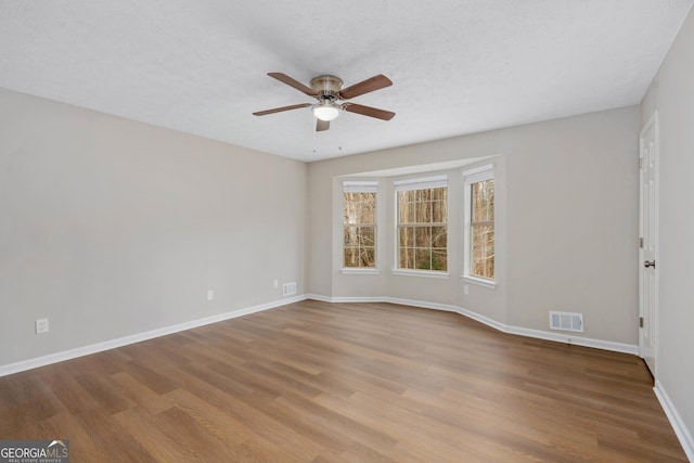 unfurnished room featuring ceiling fan, a textured ceiling, and light hardwood / wood-style floors