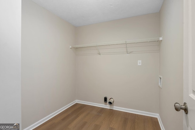 washroom with hookup for a washing machine, wood-type flooring, and a textured ceiling