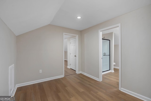 additional living space with vaulted ceiling and light hardwood / wood-style floors