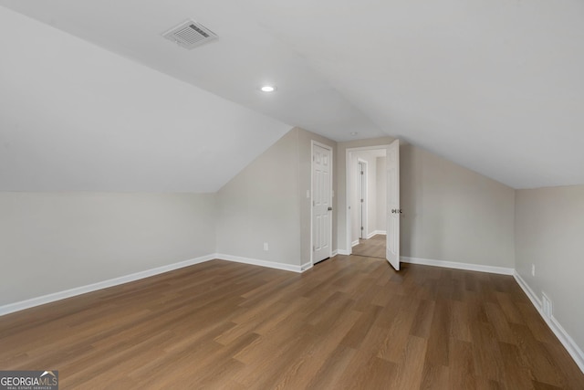 additional living space with lofted ceiling and dark wood-type flooring