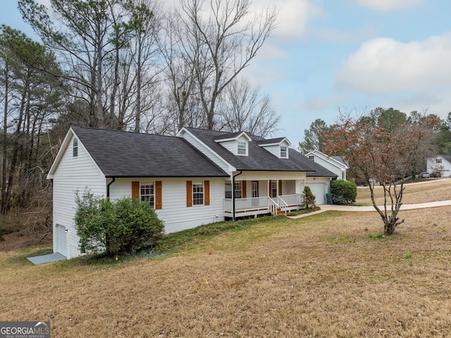 view of front of house featuring a garage, covered porch, and a front yard