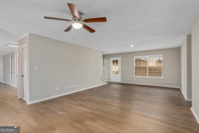 unfurnished room with a textured ceiling, light hardwood / wood-style floors, and ceiling fan