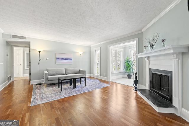 living room featuring ornamental molding, hardwood / wood-style floors, and a textured ceiling