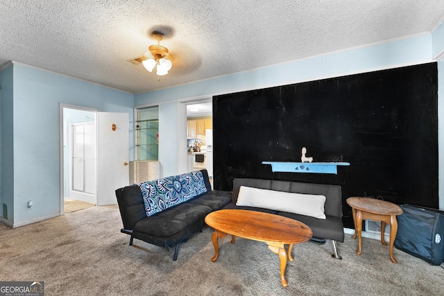 sitting room featuring ceiling fan, carpet flooring, and a textured ceiling