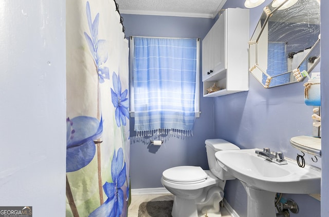 bathroom with crown molding, toilet, a shower with shower curtain, and a textured ceiling