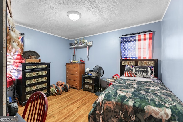 bedroom featuring crown molding, wood-type flooring, and a textured ceiling