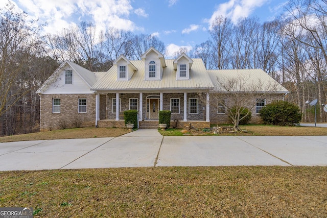 cape cod house with a front lawn and covered porch