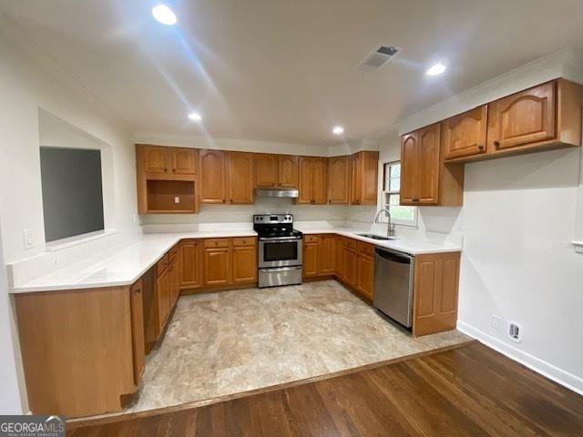 kitchen with stainless steel appliances, light hardwood / wood-style floors, and sink