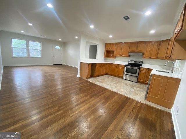 kitchen with sink, light hardwood / wood-style flooring, and stainless steel range with electric stovetop