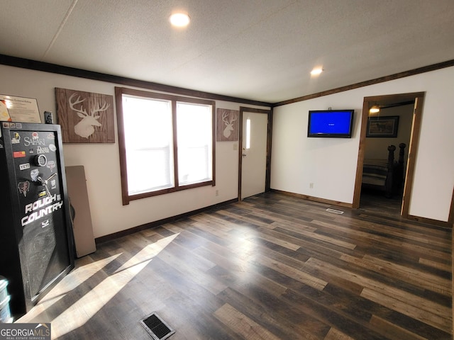 unfurnished living room featuring vaulted ceiling, dark hardwood / wood-style floors, and a textured ceiling