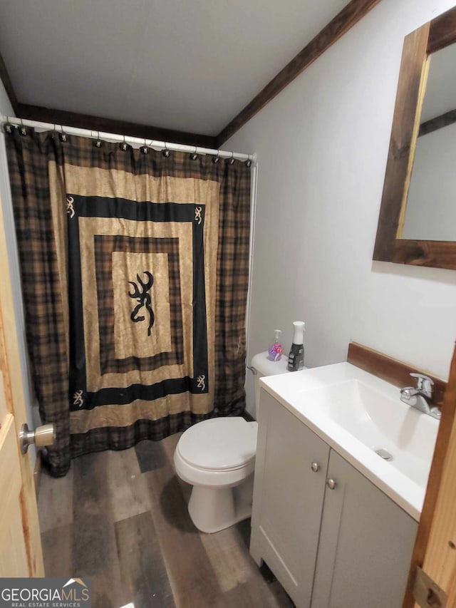 bathroom featuring wood-type flooring, ornamental molding, vanity, toilet, and a shower with curtain