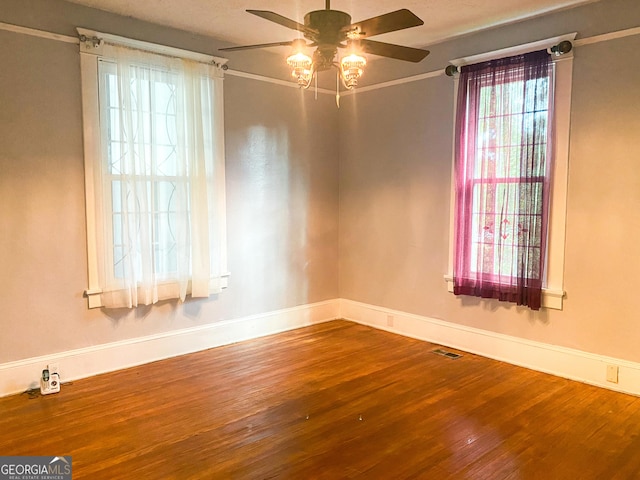 empty room with hardwood / wood-style flooring, ornamental molding, and ceiling fan