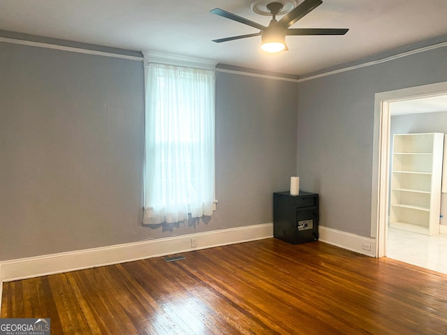 unfurnished room featuring crown molding, dark hardwood / wood-style floors, and ceiling fan