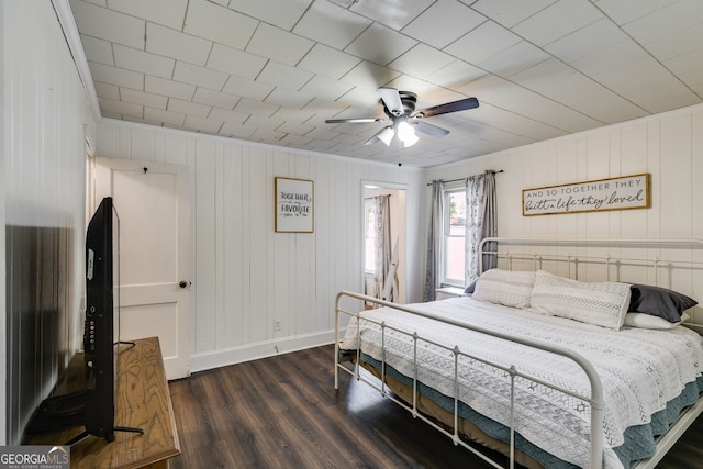 bedroom with crown molding, dark hardwood / wood-style floors, and ceiling fan