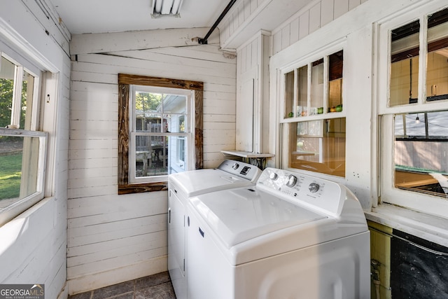 laundry room with separate washer and dryer and wood walls