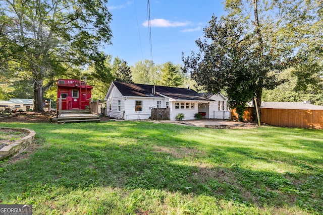 back of property with a patio, a deck, and a lawn