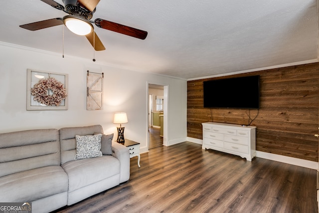 living room featuring ornamental molding, dark wood-type flooring, ceiling fan, and wood walls