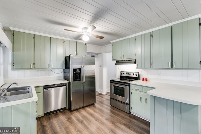 kitchen featuring green cabinets, stainless steel appliances, sink, and backsplash