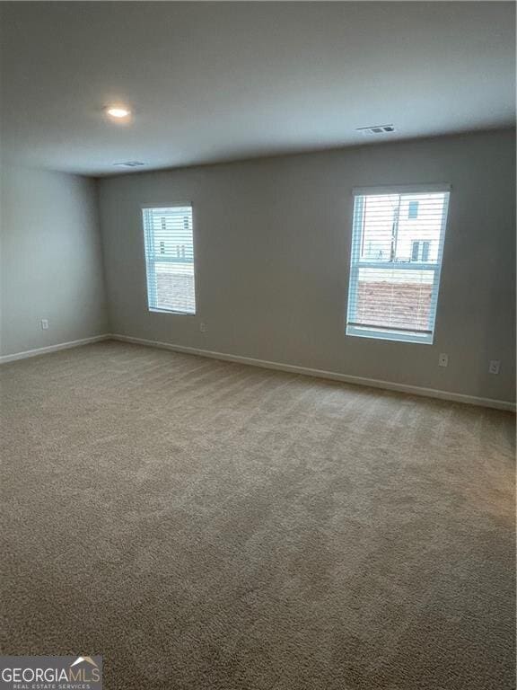 carpeted spare room featuring plenty of natural light