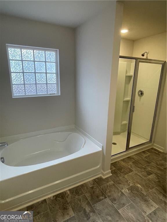 bathroom featuring independent shower and bath