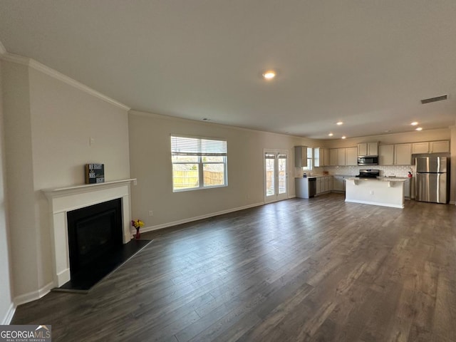 unfurnished living room featuring ornamental molding and dark hardwood / wood-style floors