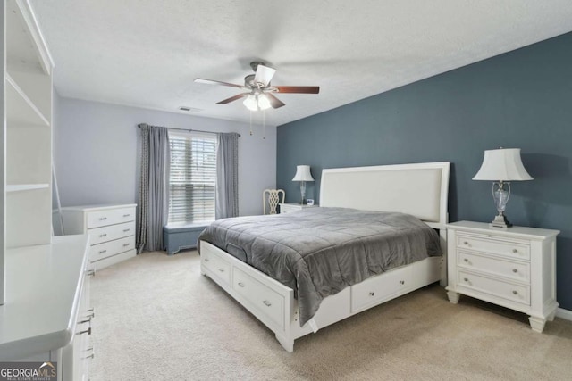 carpeted bedroom with ceiling fan and a textured ceiling