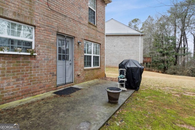 entrance to property featuring a patio and a yard