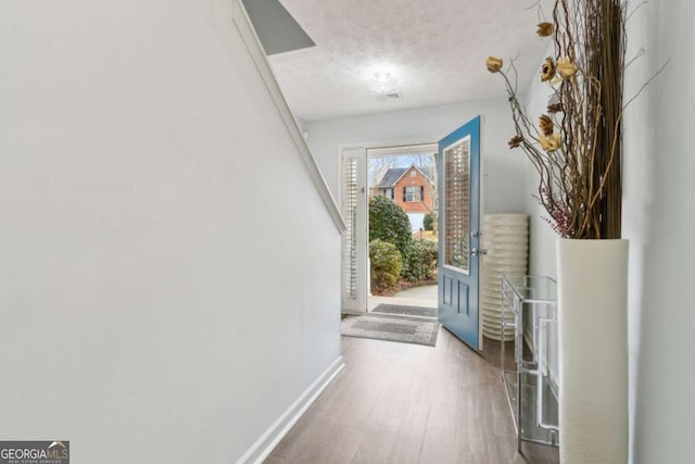 doorway with hardwood / wood-style floors and a textured ceiling