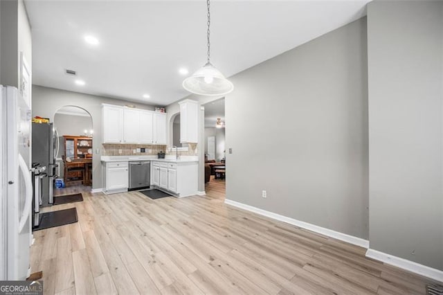 kitchen with tasteful backsplash, light hardwood / wood-style floors, white cabinets, decorative light fixtures, and stainless steel dishwasher