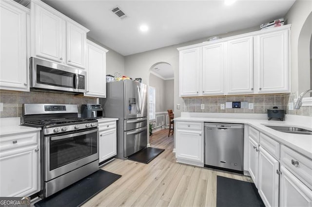 kitchen with white cabinetry, appliances with stainless steel finishes, sink, and light wood-type flooring