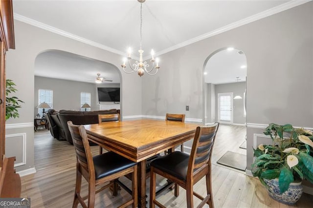 dining room featuring crown molding, ceiling fan with notable chandelier, and light wood-type flooring