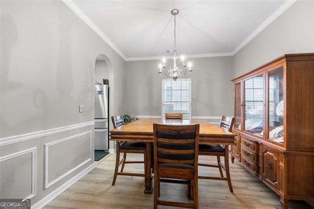 dining area featuring crown molding, a wealth of natural light, a chandelier, and light wood-type flooring