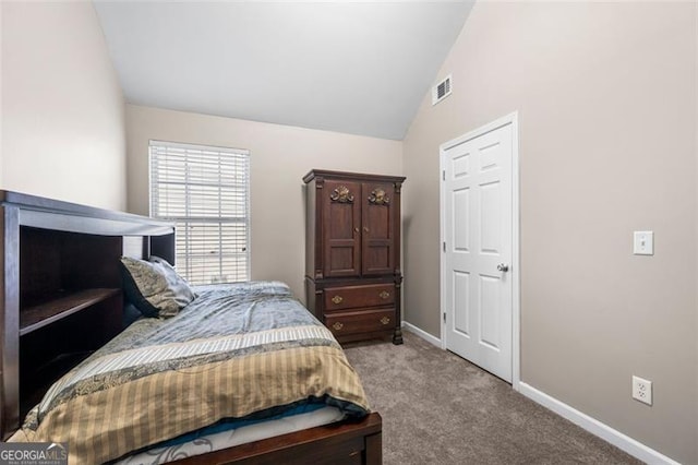 bedroom featuring lofted ceiling and light carpet