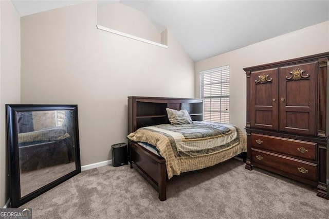 carpeted bedroom with lofted ceiling