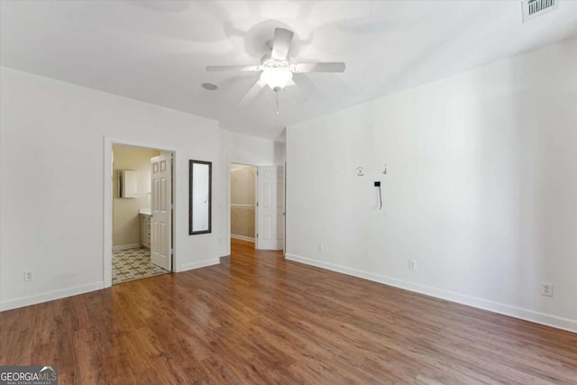 unfurnished bedroom with wood-type flooring and ensuite bathroom