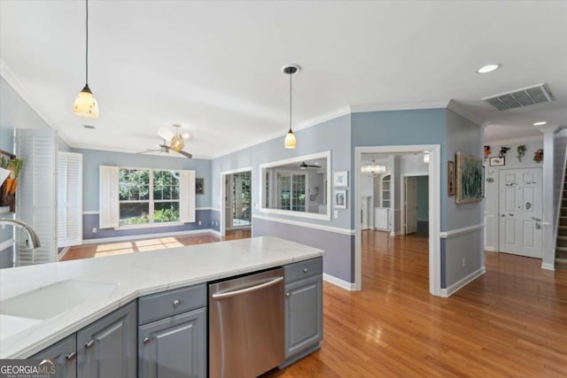 kitchen with gray cabinets, pendant lighting, sink, stainless steel dishwasher, and light stone countertops