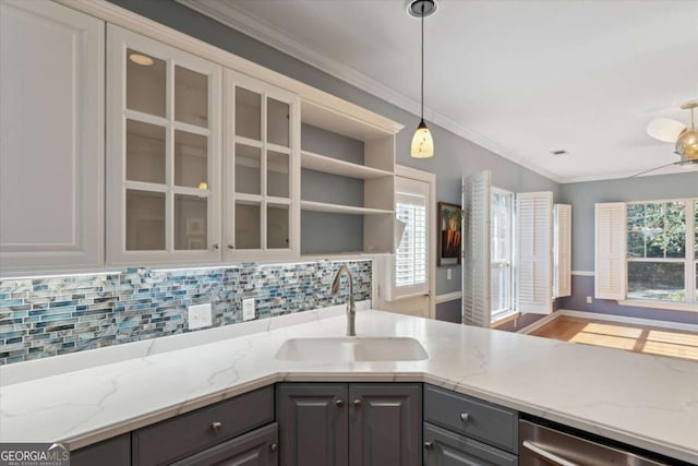 kitchen with light stone counters, sink, white cabinetry, and gray cabinets