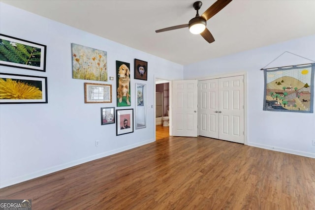 unfurnished bedroom with wood-type flooring, ceiling fan, and a closet