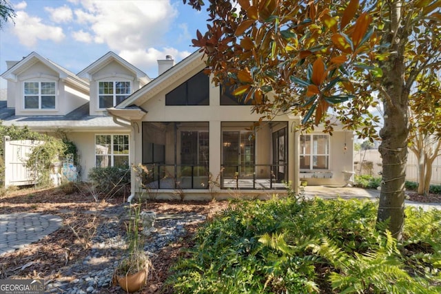 rear view of house featuring a sunroom and a patio area