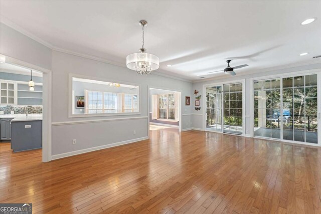 unfurnished living room with ornamental molding, a healthy amount of sunlight, and light hardwood / wood-style floors