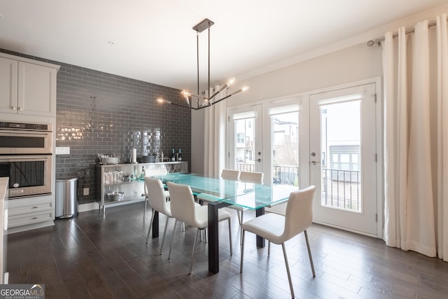 dining room with an inviting chandelier and dark wood-type flooring