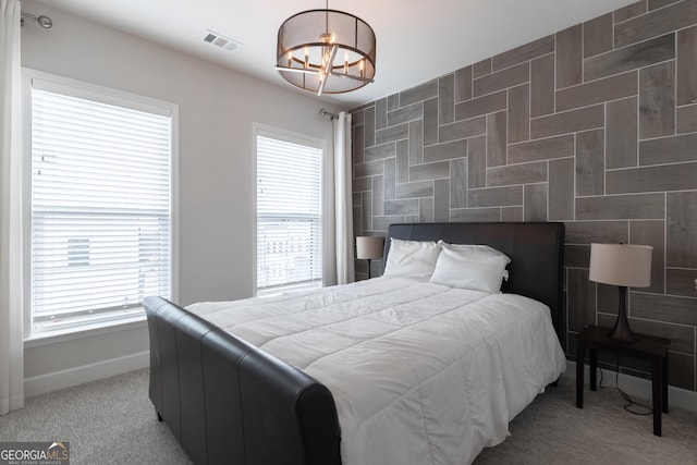 carpeted bedroom featuring a chandelier