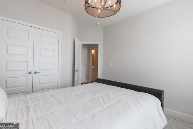 carpeted bedroom featuring an inviting chandelier and a closet