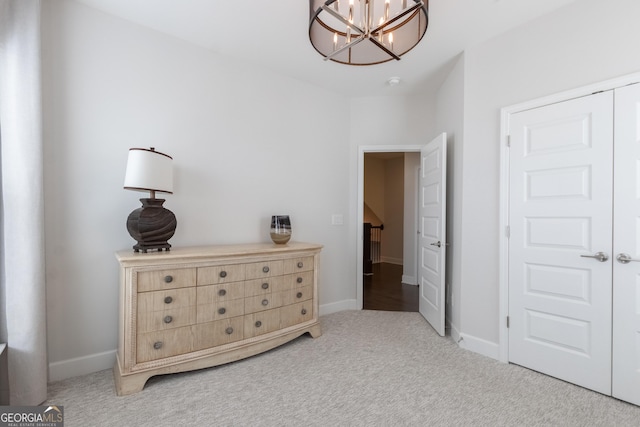 bedroom with an inviting chandelier, carpet floors, and a closet