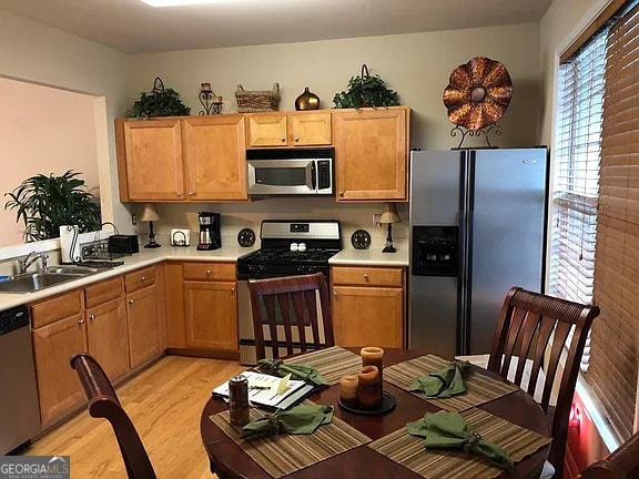 kitchen with sink, light hardwood / wood-style floors, and appliances with stainless steel finishes